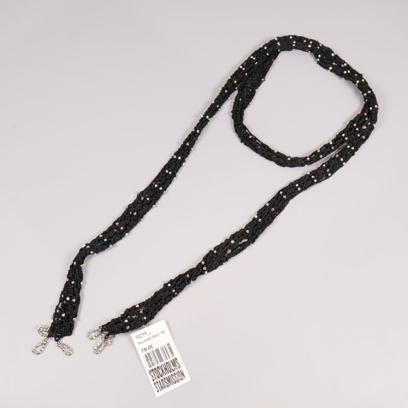 Svart flätat halsband med silverfärgade pärlor på vit bakgrund