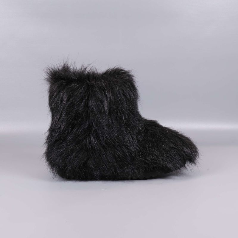 Svarta boots med lång päls fotograferade från sidan