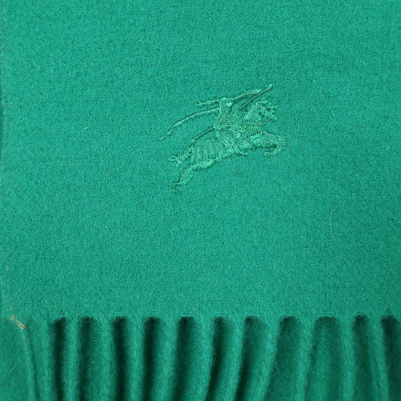 Broderad logotyp på grön halsduk nära franskant
