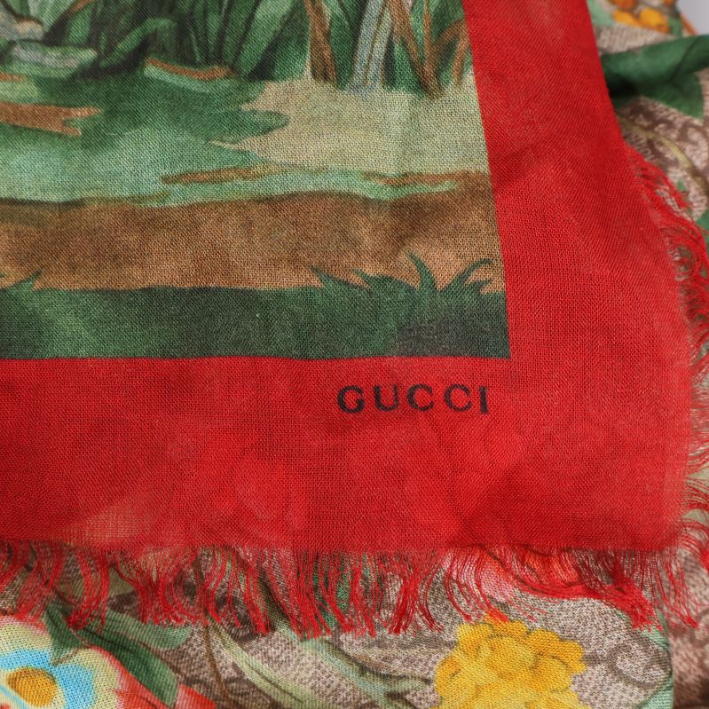 Gucci-tryck i hörn på röd kant av scarfen