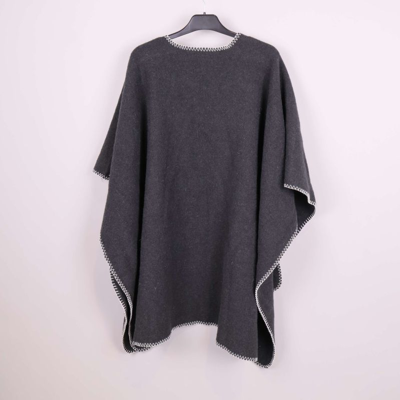 Mörkgrå poncho bakifrån med vita kontrastsömmar längs kanterna