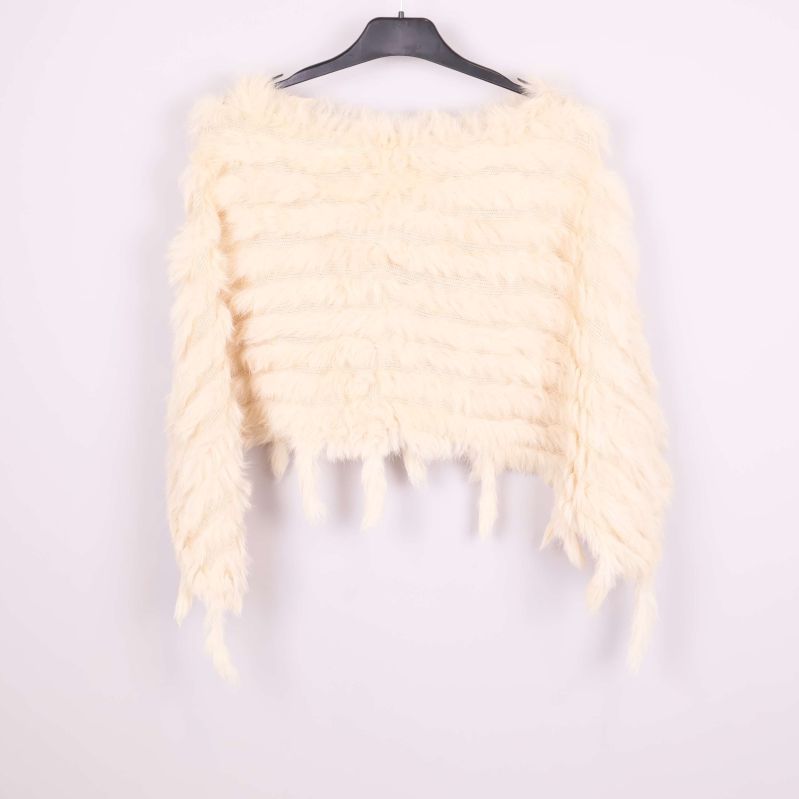 Krämvit poncho bakifrån med fluffig struktur och fransar