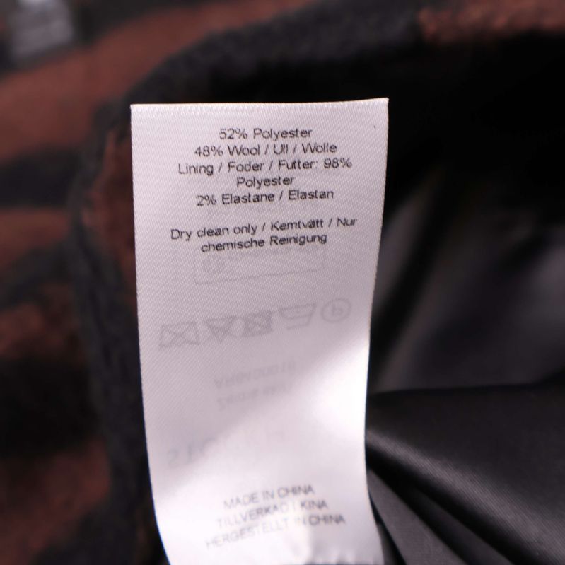 Materialetikett med polyester, viskos och foderinformation visas