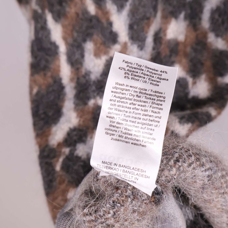 Tvättrådsetikett med materialsammansättning och skötselanvisningar