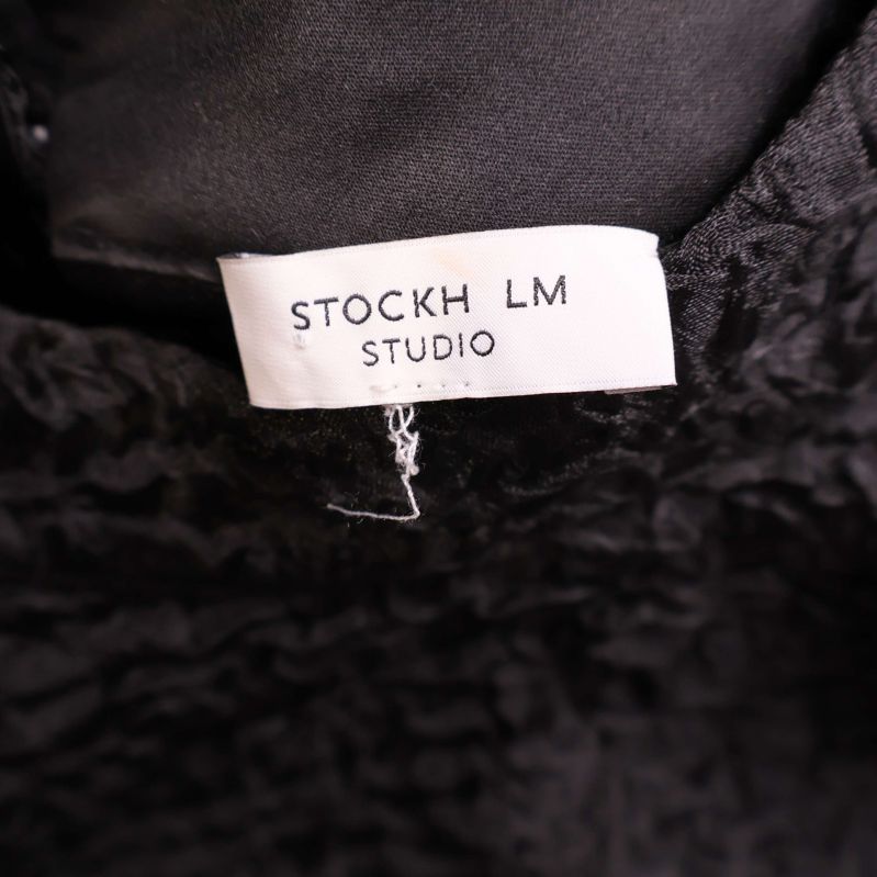 Närmåttad varumärkeslapp med text Stockh lm Studio