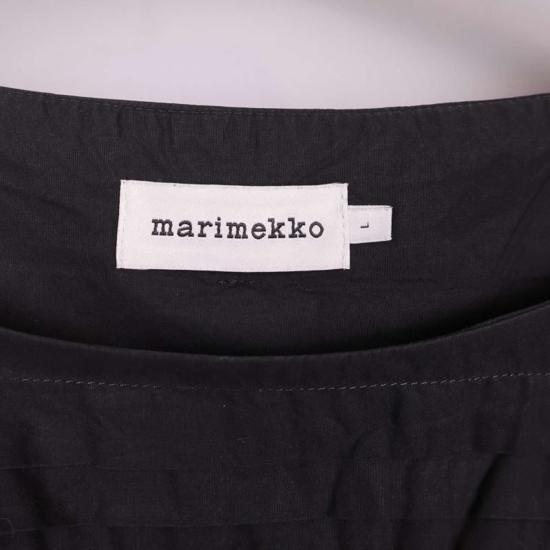 Närbild på Marimekko-etikett i svart blus