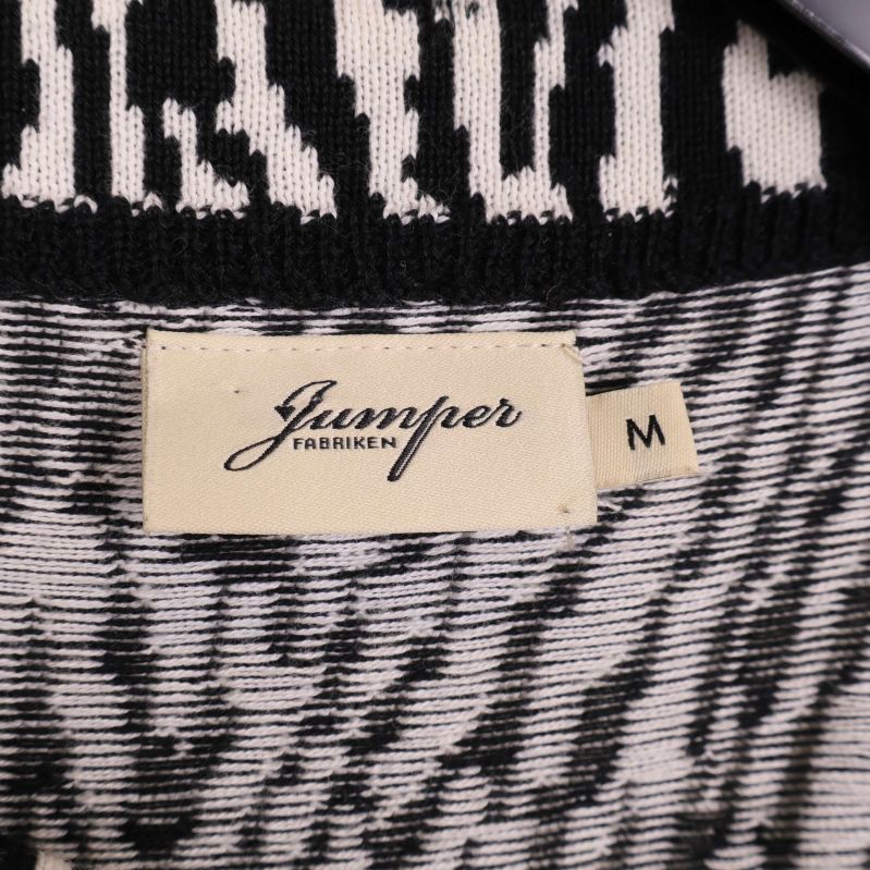 Närbild på etikett med Jumperfabriken och storlek M