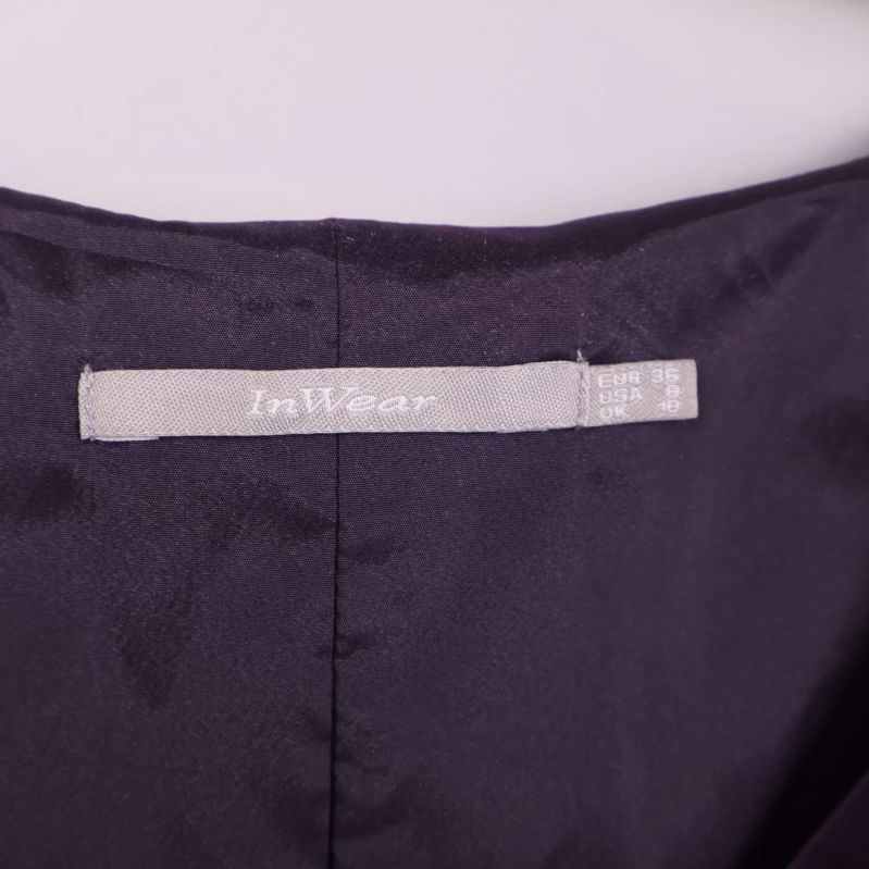 Närbild på InWear-loggan i klänningens nacke