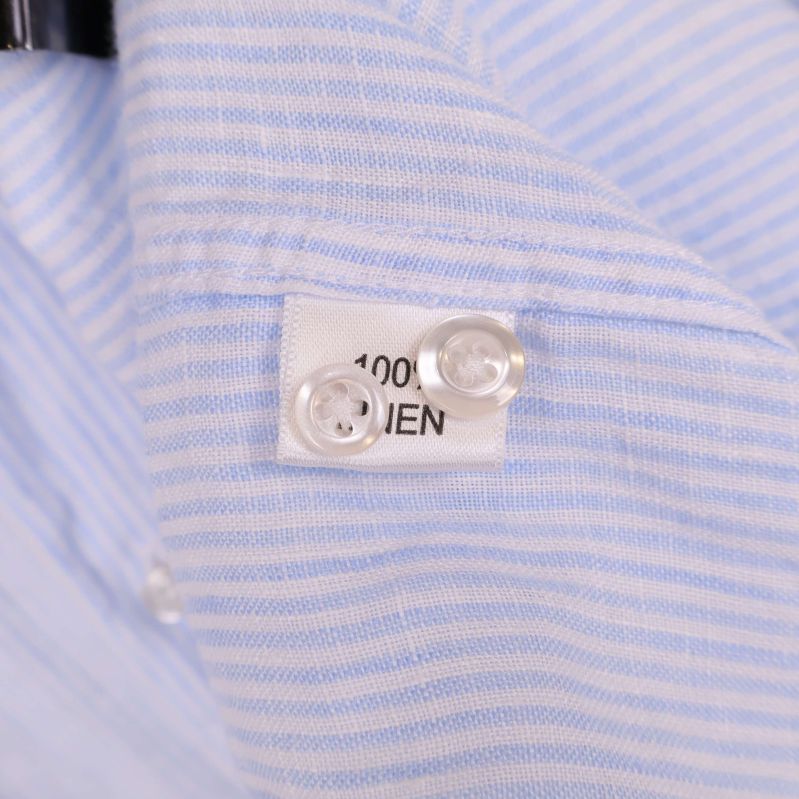 Textil- och knapptygsetikett som visar 100% linne