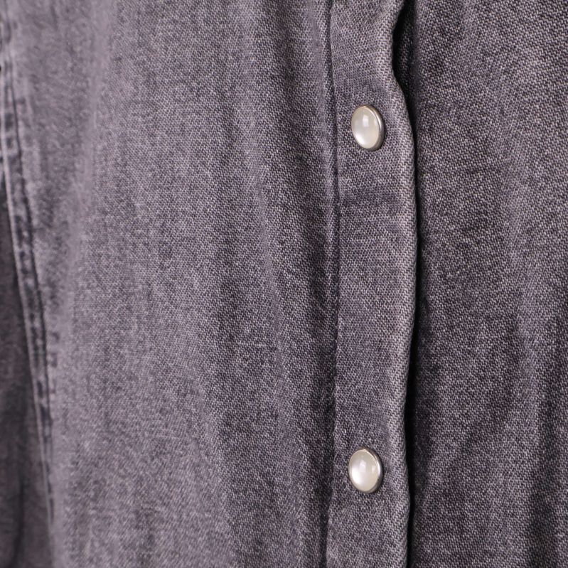 Närbild på pärlemoknappar och denimtyg