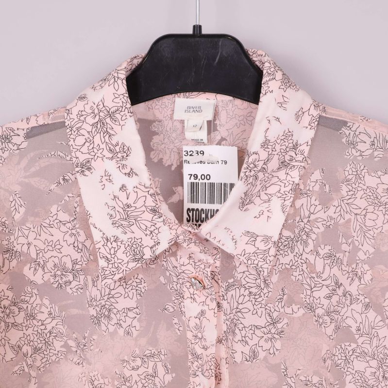 Närbild på krage och etikett på blus från River Island