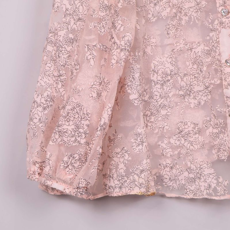 Närbild på ärmslut på blommig transparent blus