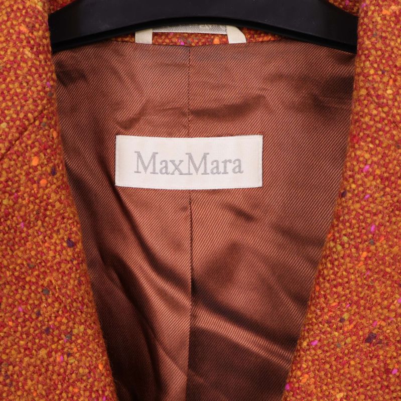 Närbild på Max Mara-logotyp i kavajens bruna foder